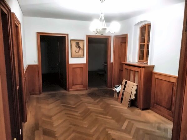 Hol z drewnianą boazerią i parkietem w jodełkę
